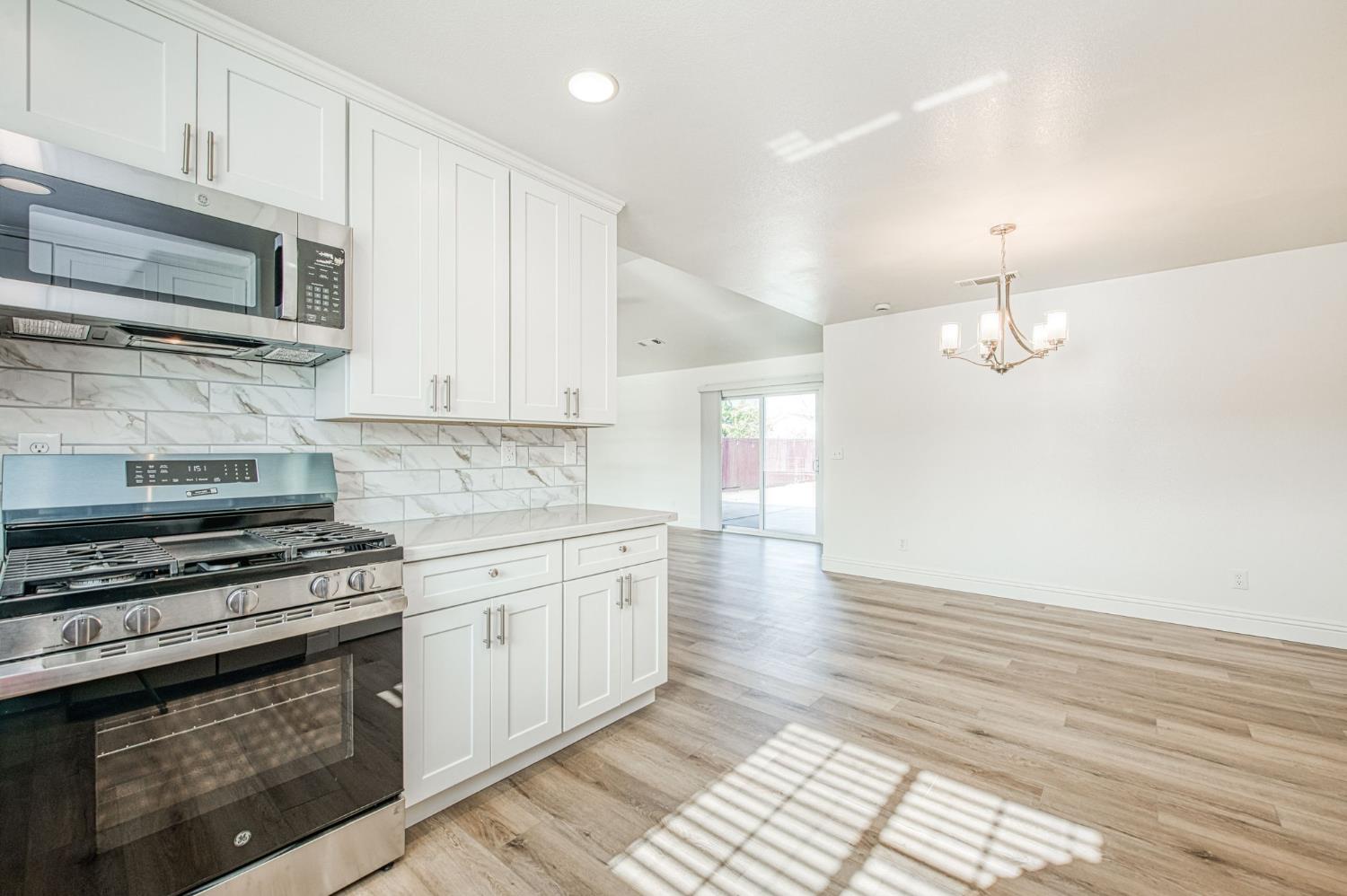 5176 West Michigan Avenue Fresno, CA 93722 - Photo 31 of 37 a kitchen with stainless steel appliances a stove a microwave and cabinets