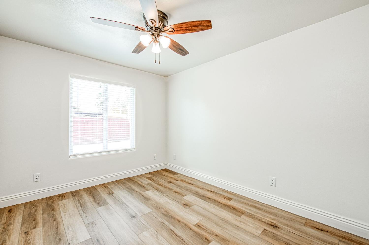 5176 West Michigan Avenue Fresno, CA 93722 - Photo 36 of 37 an empty room with a window and a ceiling fan