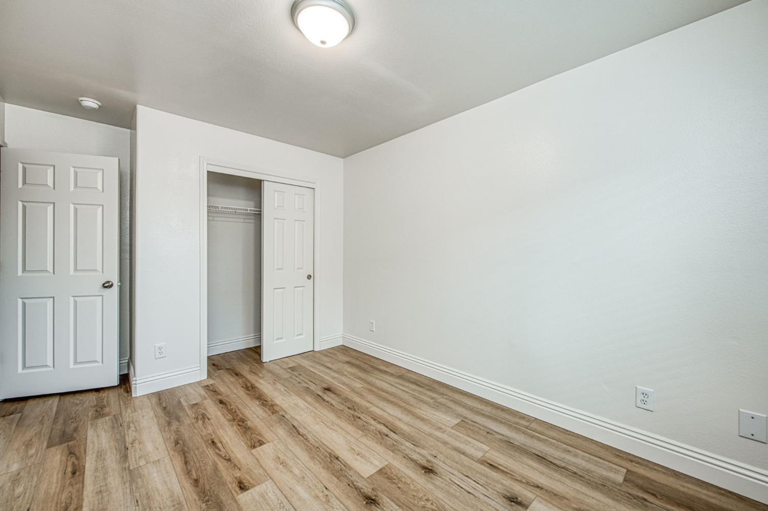 5176 West Michigan Avenue Fresno, CA 93722 - Photo 8 of 37 a view of a room with wooden floor and closet