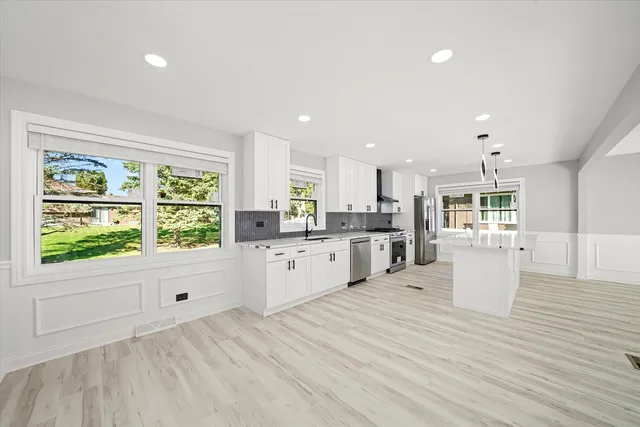 a large white kitchen with a large window