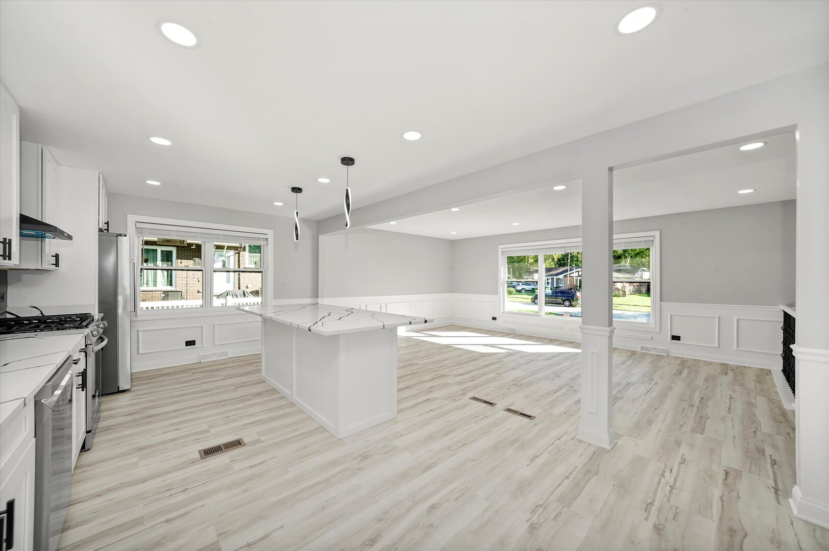 513 Chestnut Lane Beecher, IL 60401 - Photo 8 of 38 a large kitchen with kitchen island a stove a sink dishwasher a refrigerator and white cabinets with wooden floor