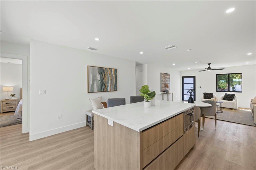 3613 Poplar Way Naples, FL 34112 - Photo 13 of 43 a view of kitchen island with furniture and wooden floor