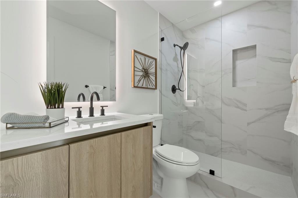 3613 Poplar Way Naples, FL 34112 - Photo 20 of 43 a bathroom with a granite countertop sink a toilet and shower