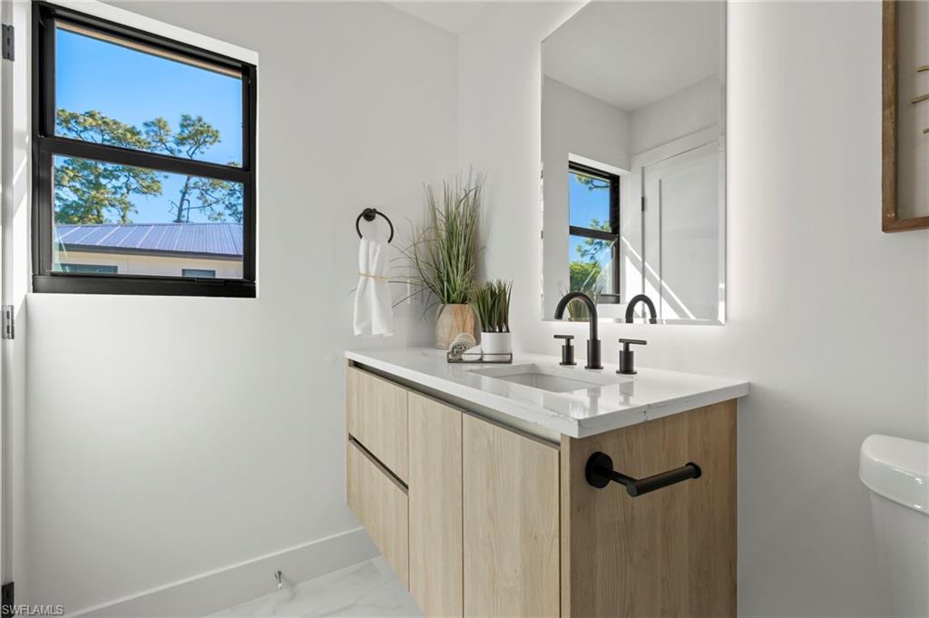 3613 Poplar Way Naples, FL 34112 - Photo 21 of 43 a bathroom with a sink and a mirror