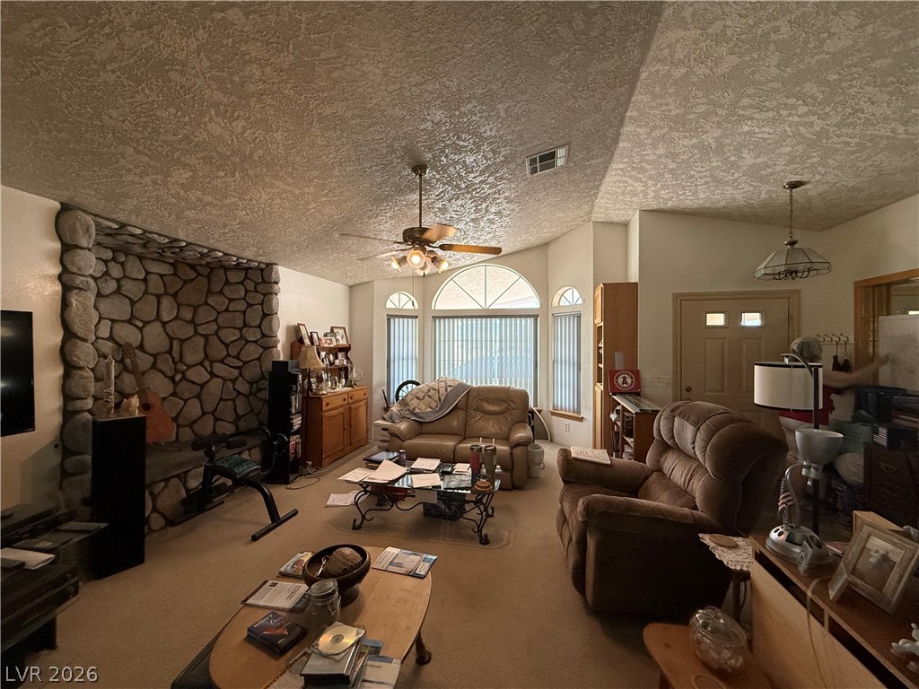 2171 South Blagg Road Pahrump, NV 89048 - Photo 7 of 27 A spacious living room welcomes with a natural stone fireplace and vaulted ceilings.