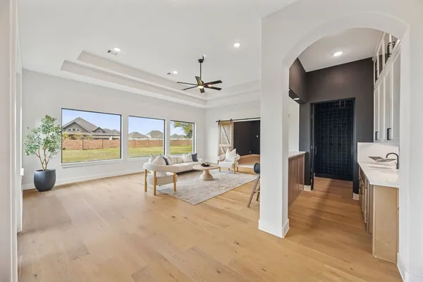 a view of a living room with stainless steel appliances wooden floor and a large window