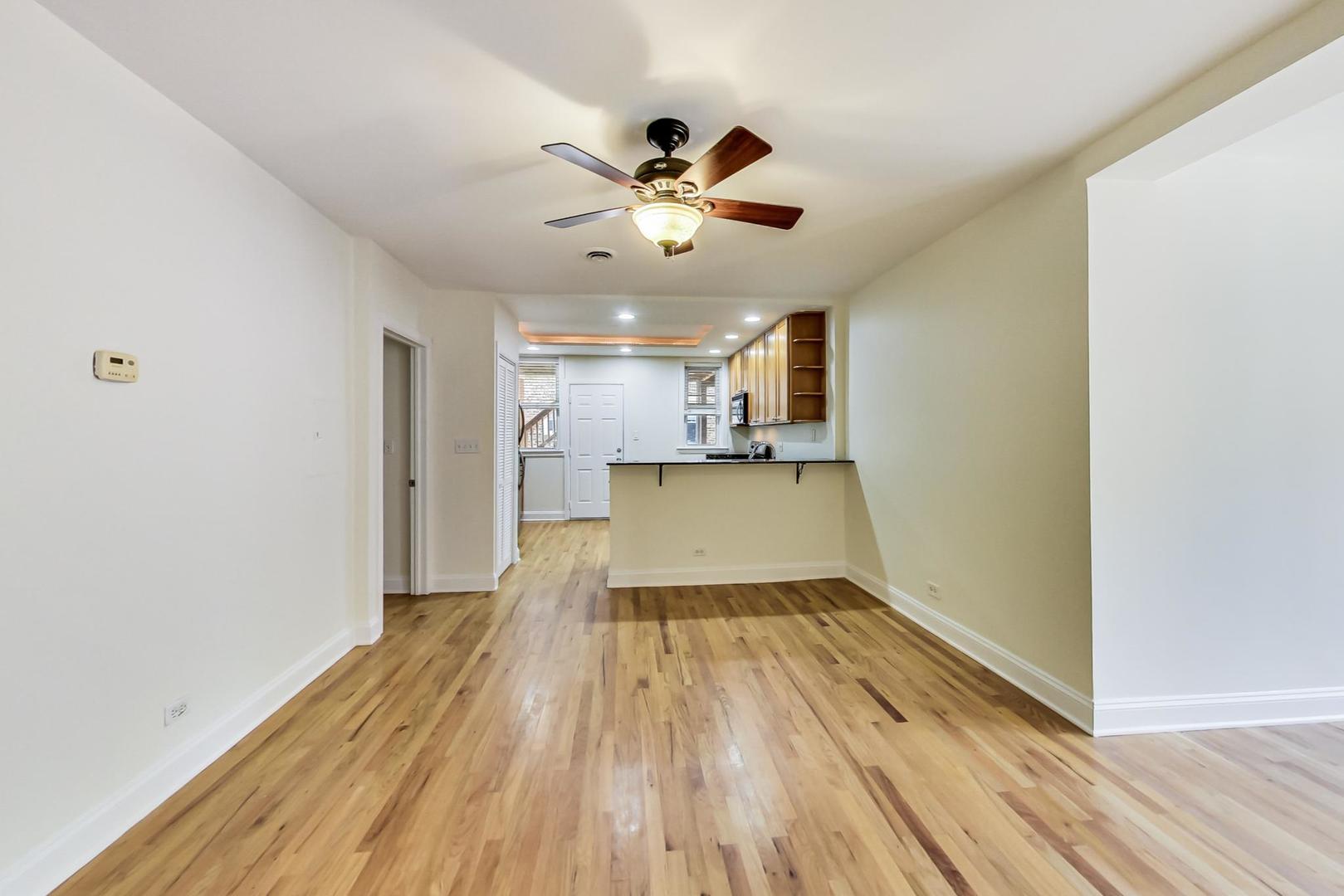 4109 North Sheridan Road, Unit 2S Chicago, IL 60613 - Photo 3 of 17 a view of a big room with wooden floor a ceiling fan and windows