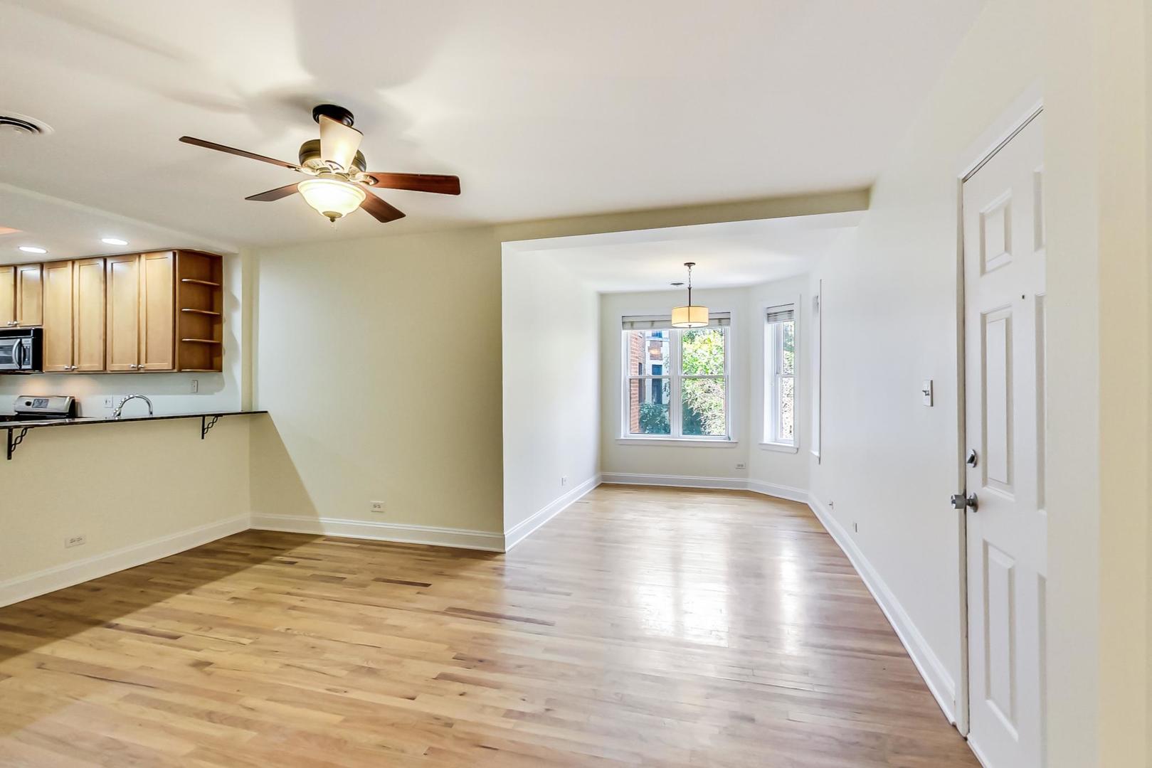 4109 North Sheridan Road, Unit 2S Chicago, IL 60613 - Photo 4 of 17 wooden floor in an empty room with a window