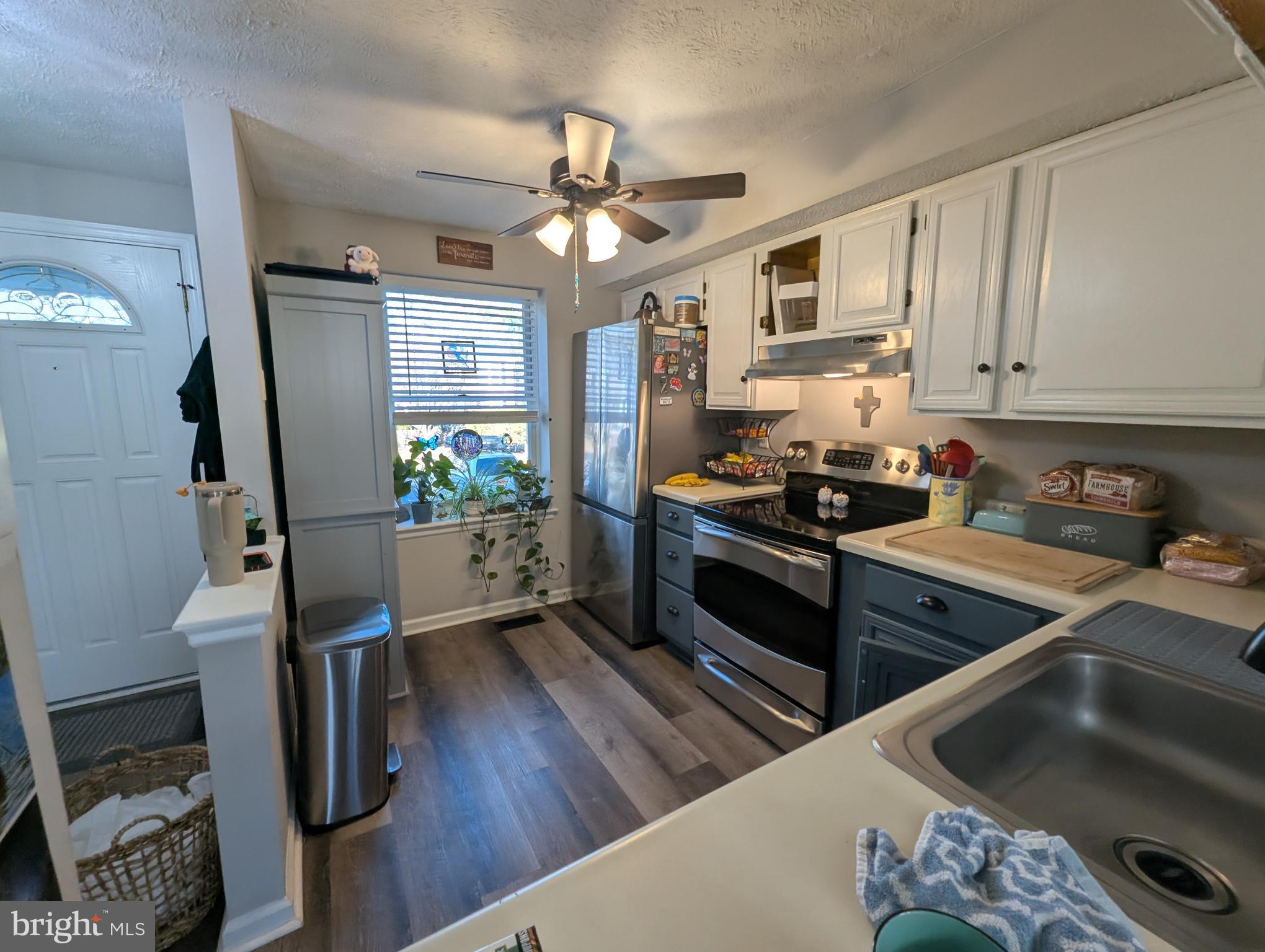 3639 Handel Court, Unit 75 Pasadena, MD 21122 - Photo 4 of 24 a kitchen with stainless steel appliances granite countertop a stove refrigerator and wooden floor