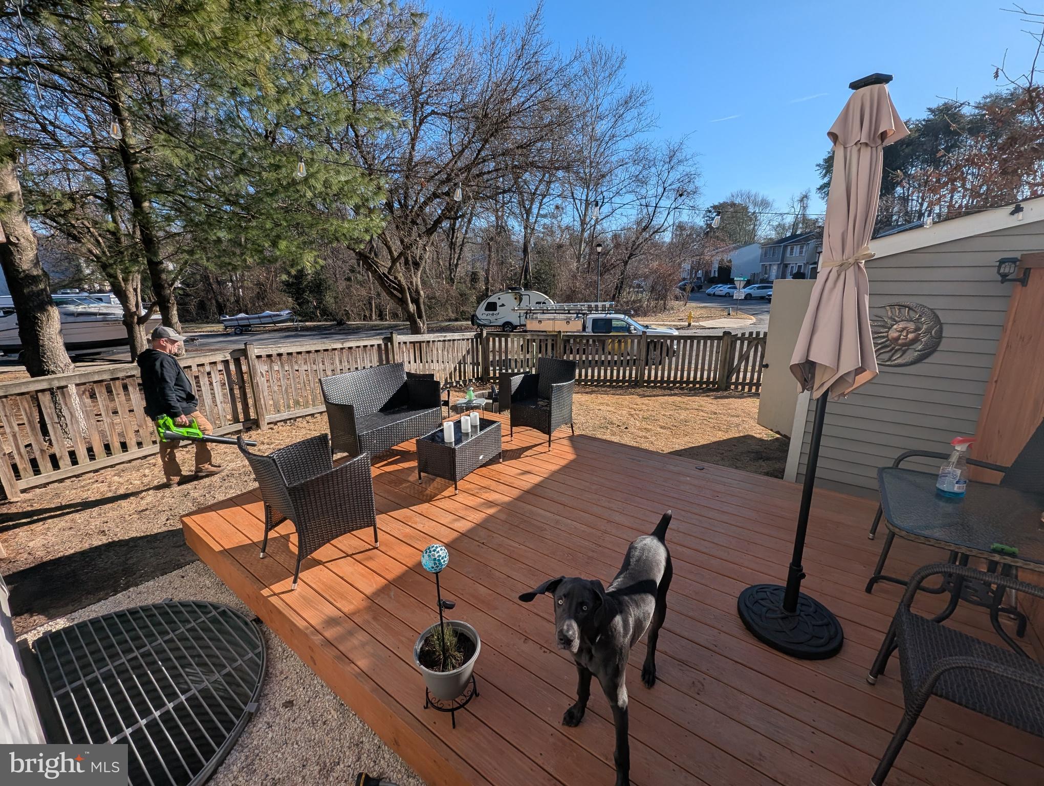 3639 Handel Court, Unit 75 Pasadena, MD 21122 - Photo 7 of 24 a view of a patio with dining table and chairs with wooden floor and fence