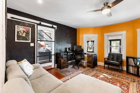 a living room with furniture rug and wall painting