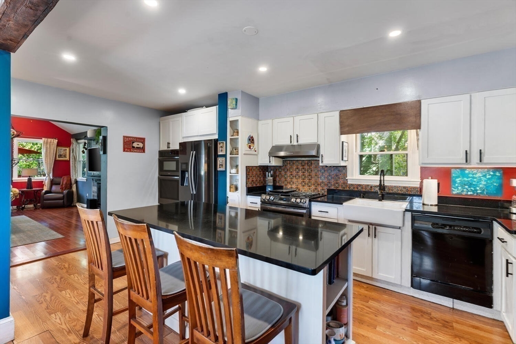 28 Gordon Road Medford, MA 02155 - Photo 3 of 41 a kitchen with stainless steel appliances granite countertop a stove top oven a refrigerator a sink and a dining table with white cabinets