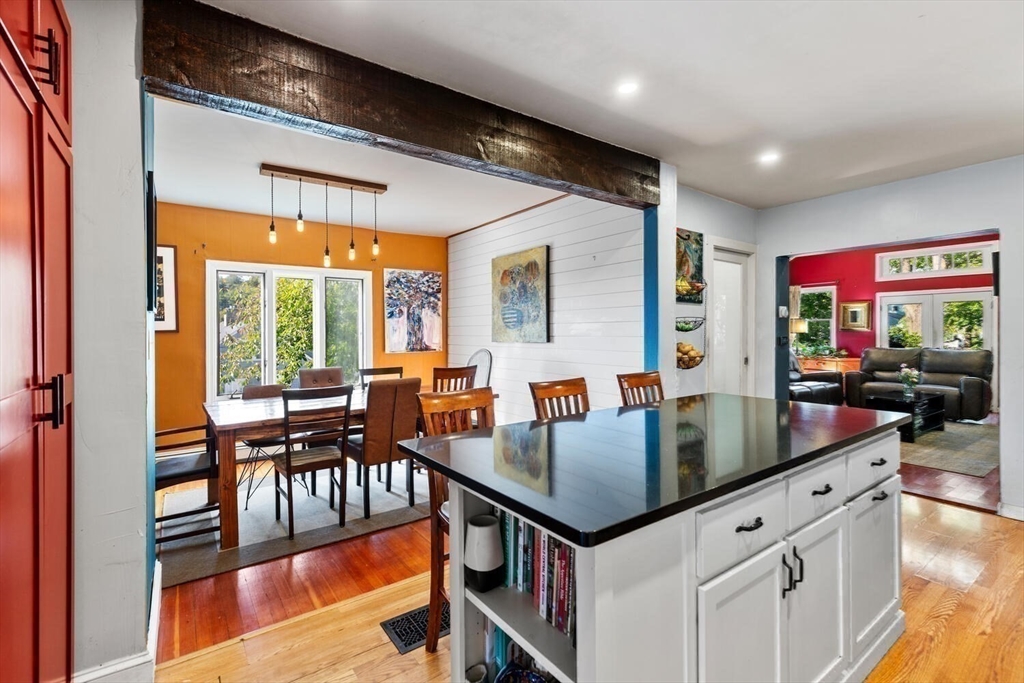 28 Gordon Road Medford, MA 02155 - Photo 8 of 41 a kitchen with stainless steel appliances granite countertop a stove a refrigerator a dining table and chairs with wooden floor
