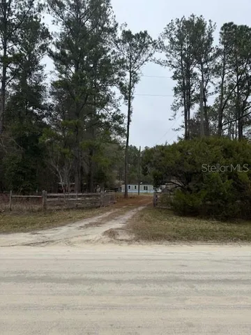 a view of a yard with wooden fence