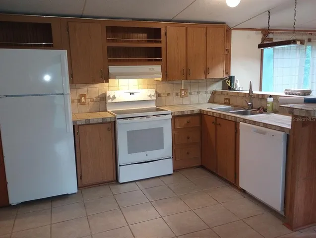 a kitchen with a sink cabinets and appliances