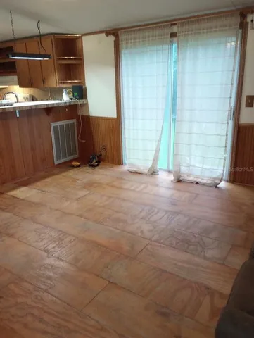 a view of an empty room with a kitchen
