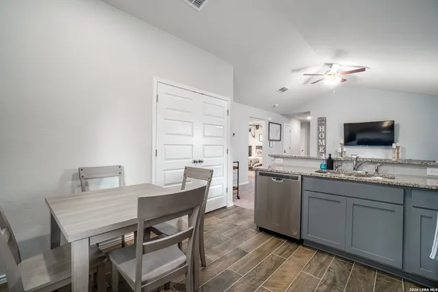 a kitchen with a dining table chairs and white cabinets