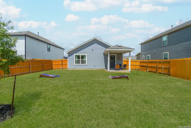 a backyard of a house with barbeque oven table and chairs