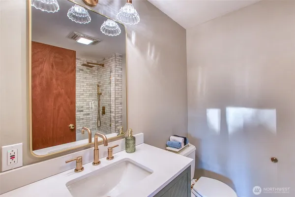 a bathroom with a sink vanity mirror and toilet
