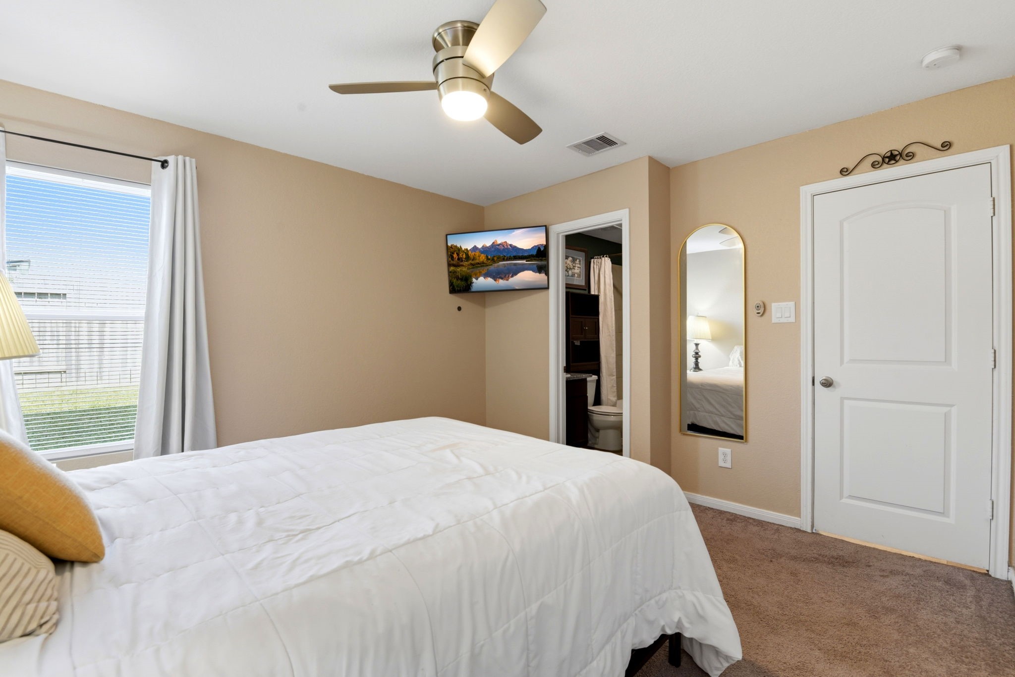 9819 Emerald Stone Way Conroe, TX 77306 - Photo 23 of 38 a bedroom with a large bed and a chandelier