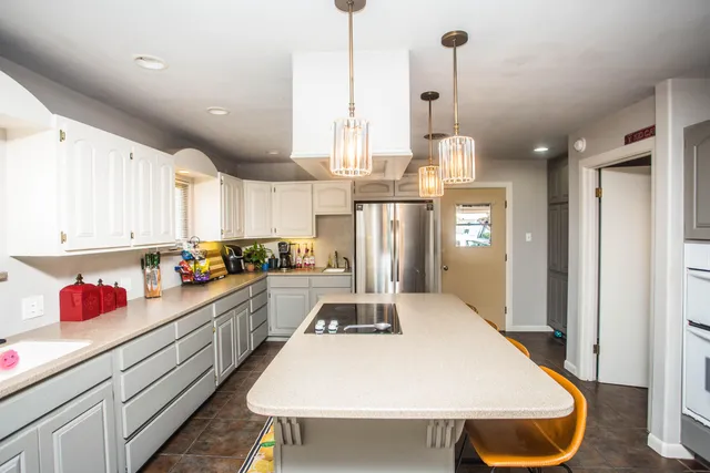 a kitchen with kitchen island a counter space a sink appliances and cabinets