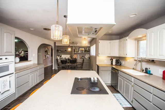 a large kitchen with a large counter top appliances and cabinets