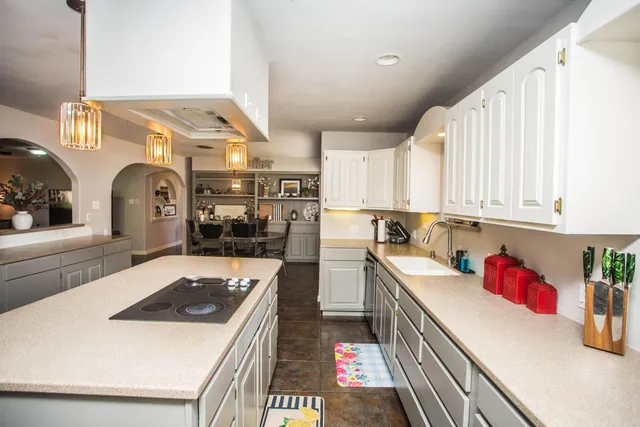 a kitchen with a sink a stove and cabinets