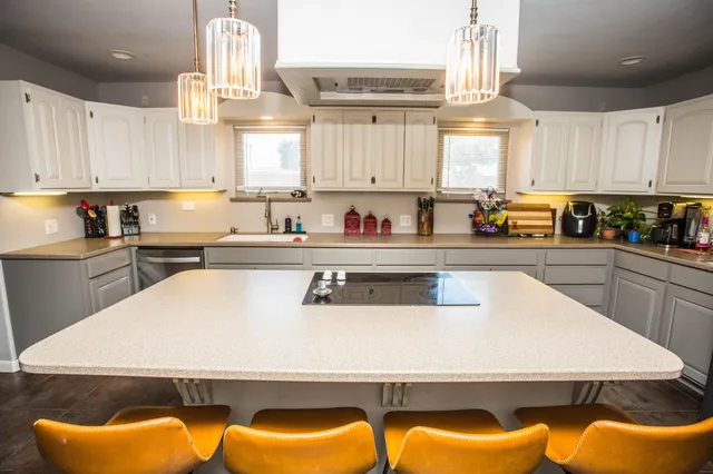 a kitchen with granite countertop a sink a stove and cabinets