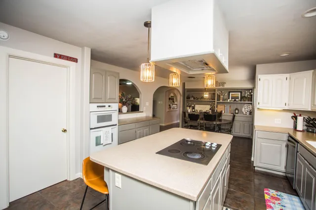 a kitchen with a refrigerator a stove and white cabinets