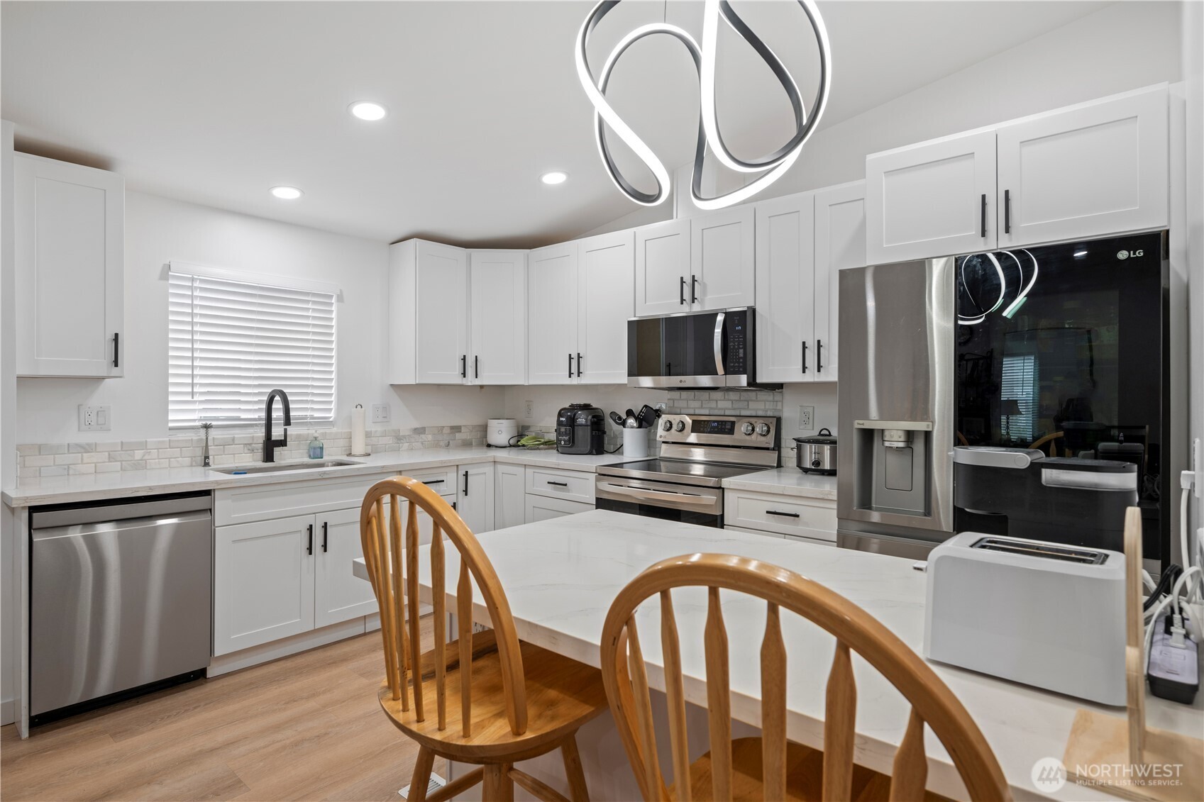 415 Lakeview Road, Unit K35 Lynnwood, WA 98087 - Photo 13 of 27 a kitchen with stainless steel appliances granite countertop a table chairs microwave and sink