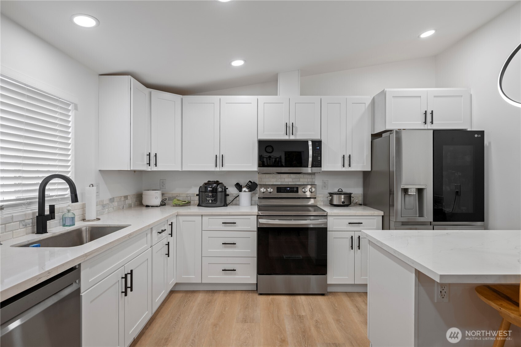 415 Lakeview Road, Unit K35 Lynnwood, WA 98087 - Photo 14 of 27 a kitchen with stainless steel appliances a sink dishwasher a refrigerator and a stove with wooden floor