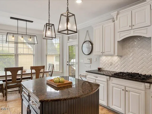 a kitchen with granite countertop a sink a stove and cabinets