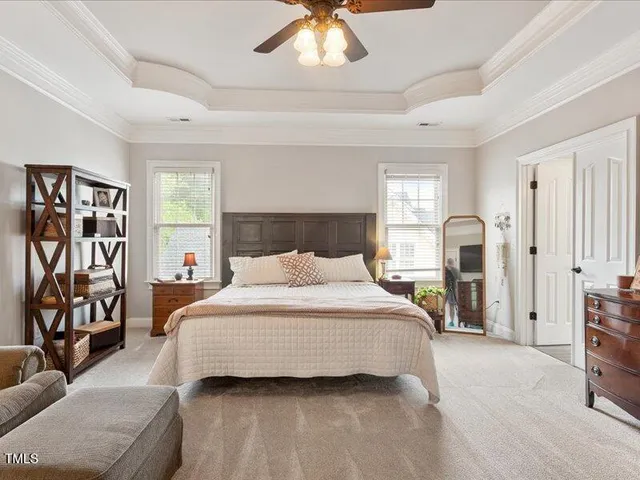 a spacious bedroom with a bed and a chandelier