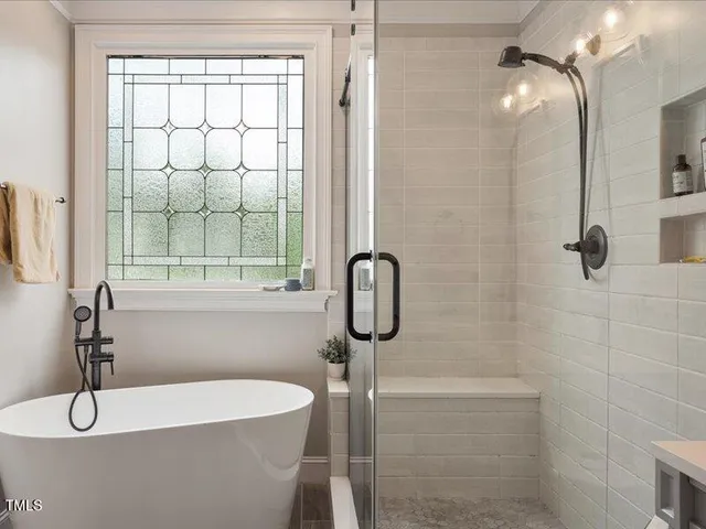 a spacious bathroom with a double vanity sink a mirror and a bathtub