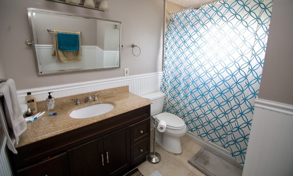 67 Dayton Street Springfield, MA 01118 - Photo 8 of 20 a bathroom with a granite countertop toilet sink and mirror