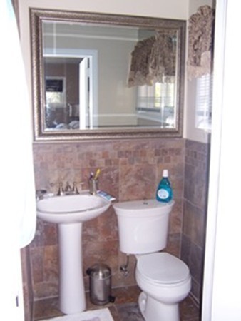67 Dayton Street Springfield, MA 01118 - Photo 10 of 20 a bathroom with a sink a toilet and mirror