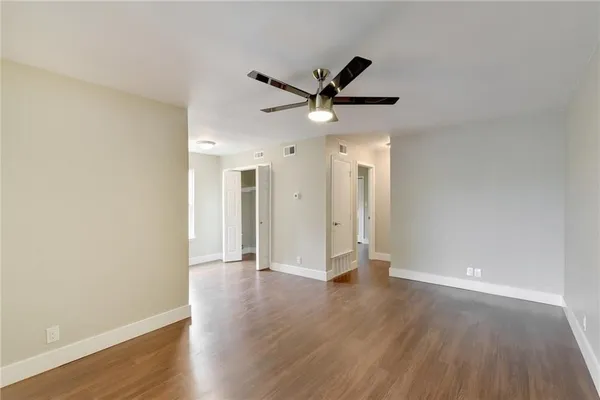 a view of an empty room with wooden floor