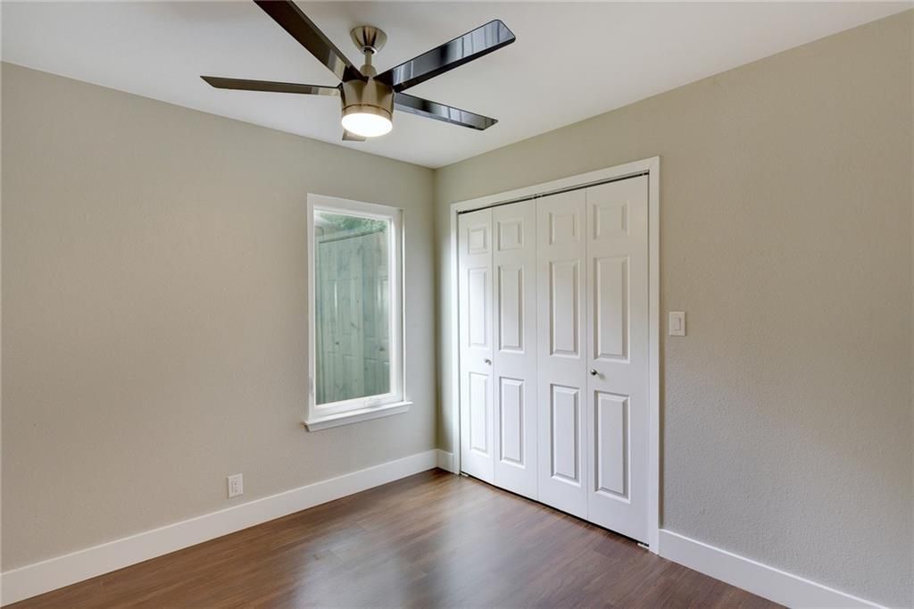 7504 Carver Avenue, Unit A Austin, TX 78752 - Photo 7 of 11 an empty room with wooden floor ceiling fan and windows