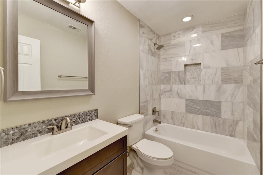 7504 Carver Avenue, Unit A Austin, TX 78752 - Photo 9 of 11 a bathroom with a sink a toilet and a bathtub