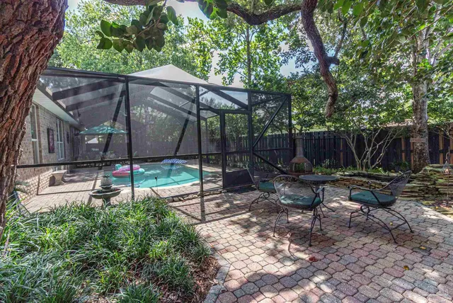 a view of a backyard with table and chairs potted plants and wooden fence