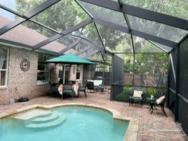 a view of a patio with table and chairs under an umbrella
