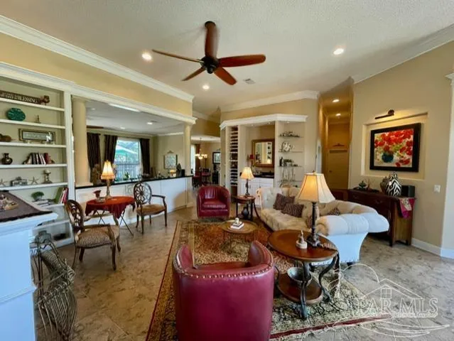 a living room with furniture kitchen view and a large window