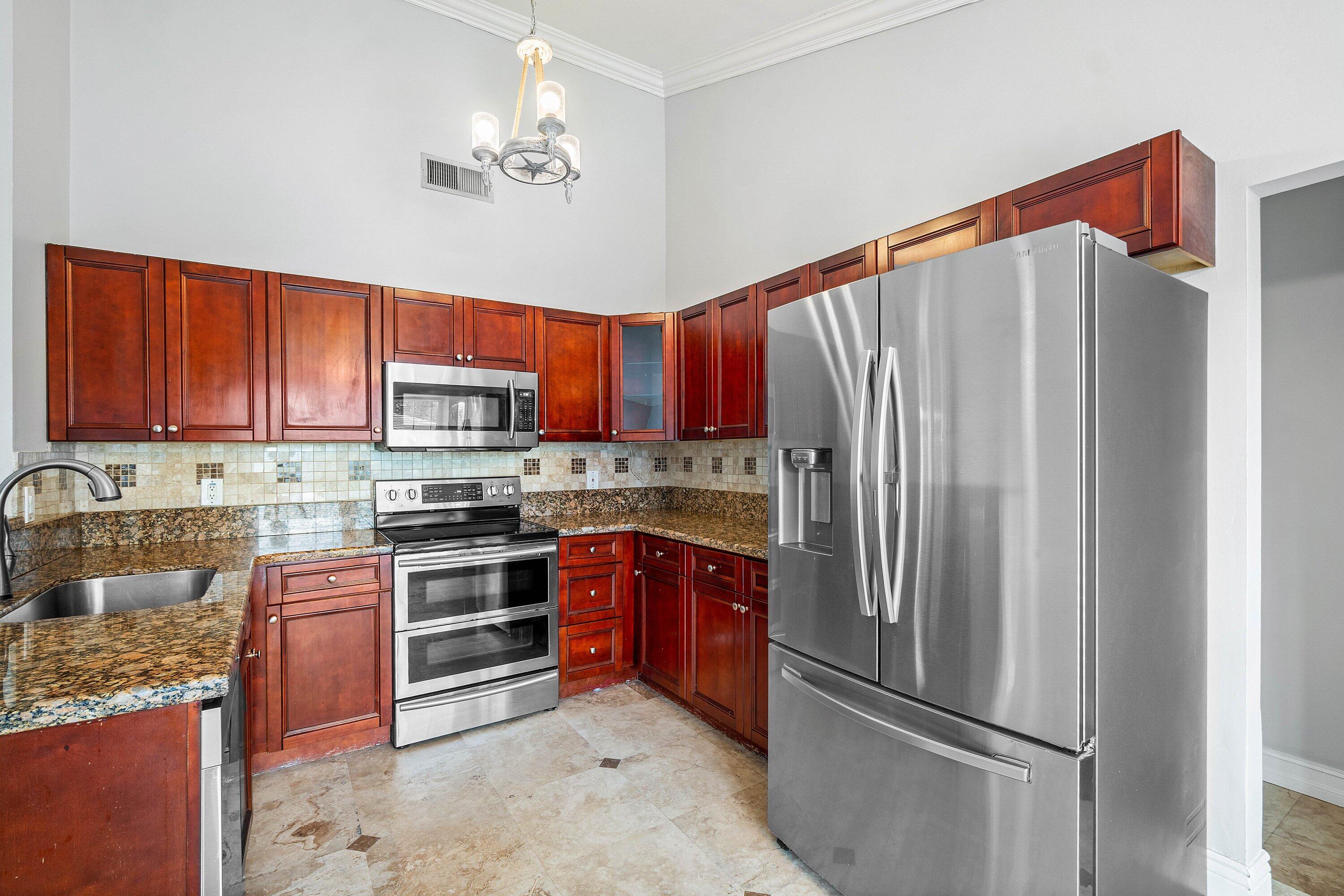8411 Garden Gate Place Boca Raton, FL 33433 - Photo 3 of 12 a kitchen with stainless steel appliances granite countertop a refrigerator stove and oven