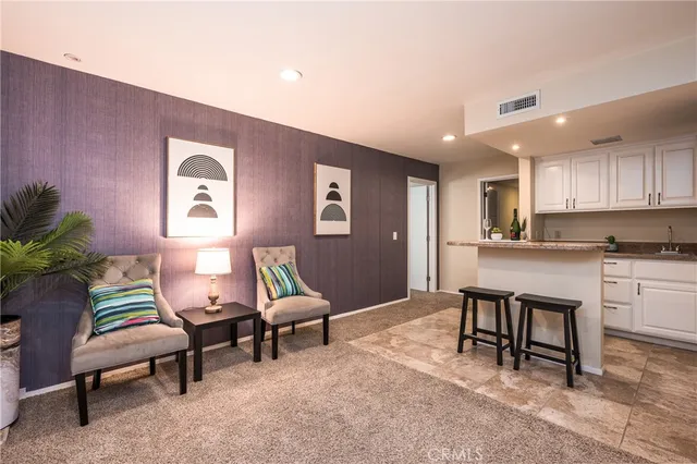 a living room with furniture and a kitchen view