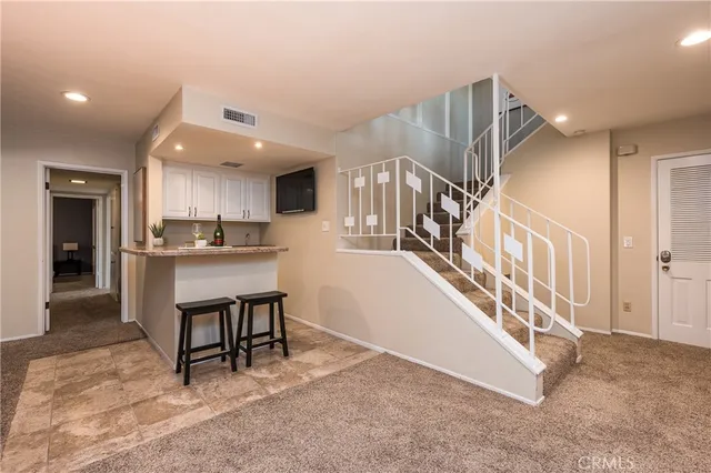 a kitchen with stainless steel appliances kitchen island granite countertop a refrigerator and a sink
