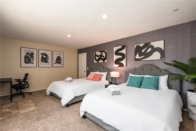 a bedroom with two beds and painting on the wall