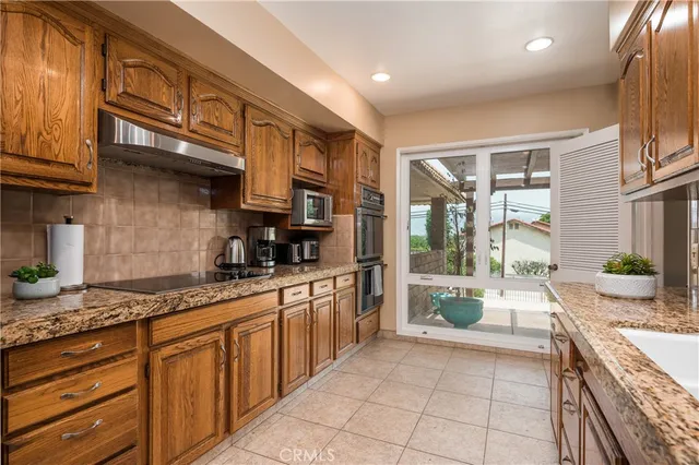 a large kitchen with stainless steel appliances granite countertop a stove and a sink