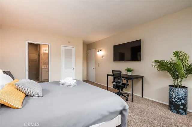 a bedroom with a bed and a flat screen tv