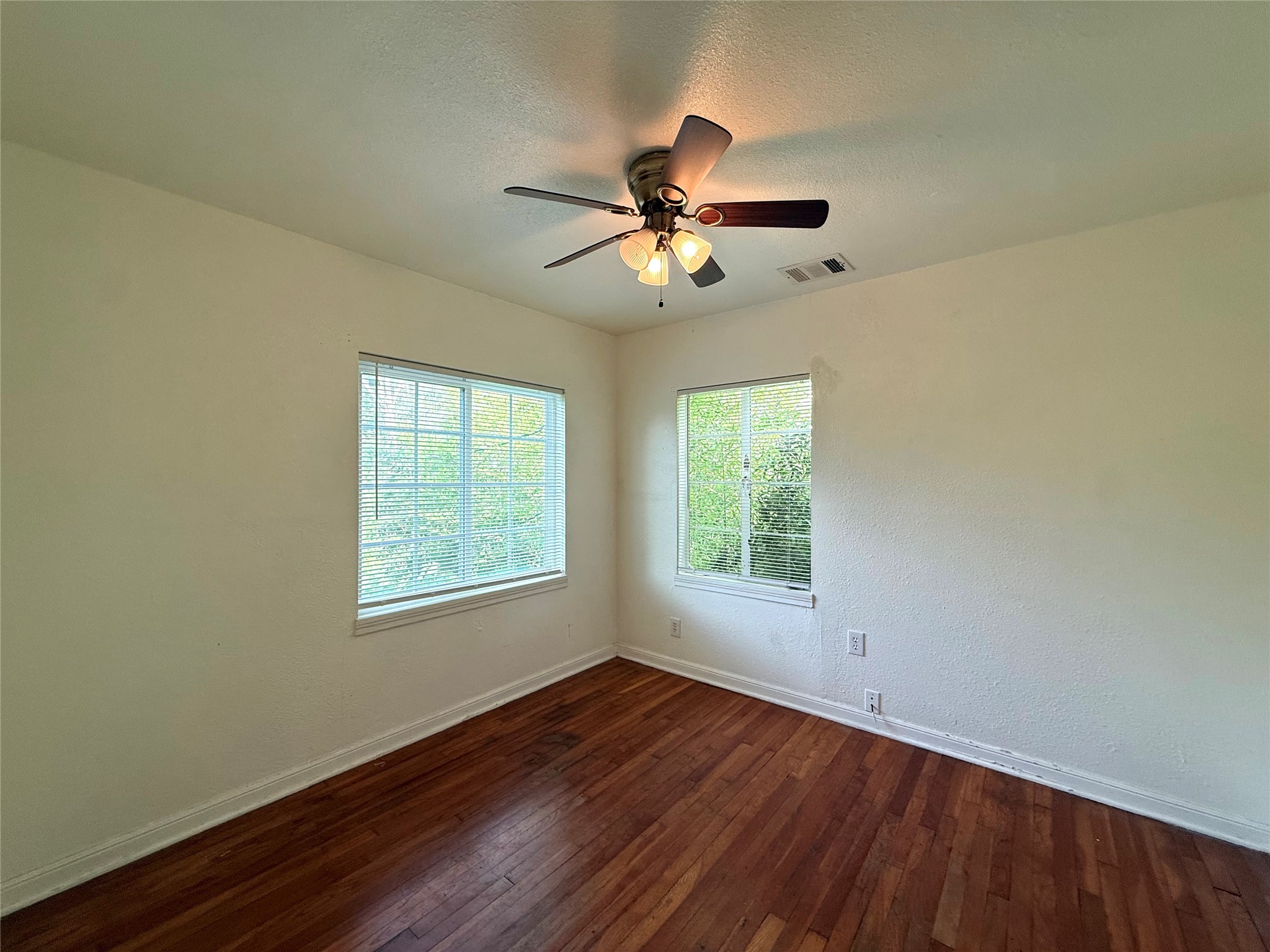 3305 Merrie Lynn Avenue Austin, TX 78722 - Photo 15 of 22 Hardwood floors and generous windows define this cozy bedroom space.