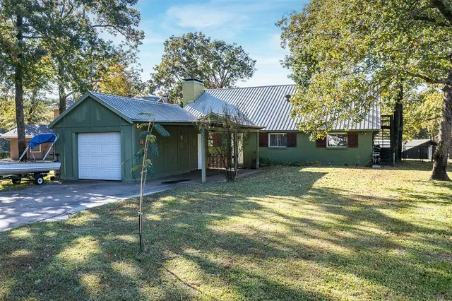 a view of a house with a yard and large tree